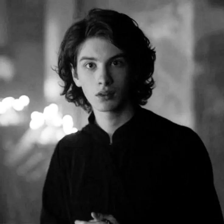 the guy with wavy hair, looking directly at the camera in black and white