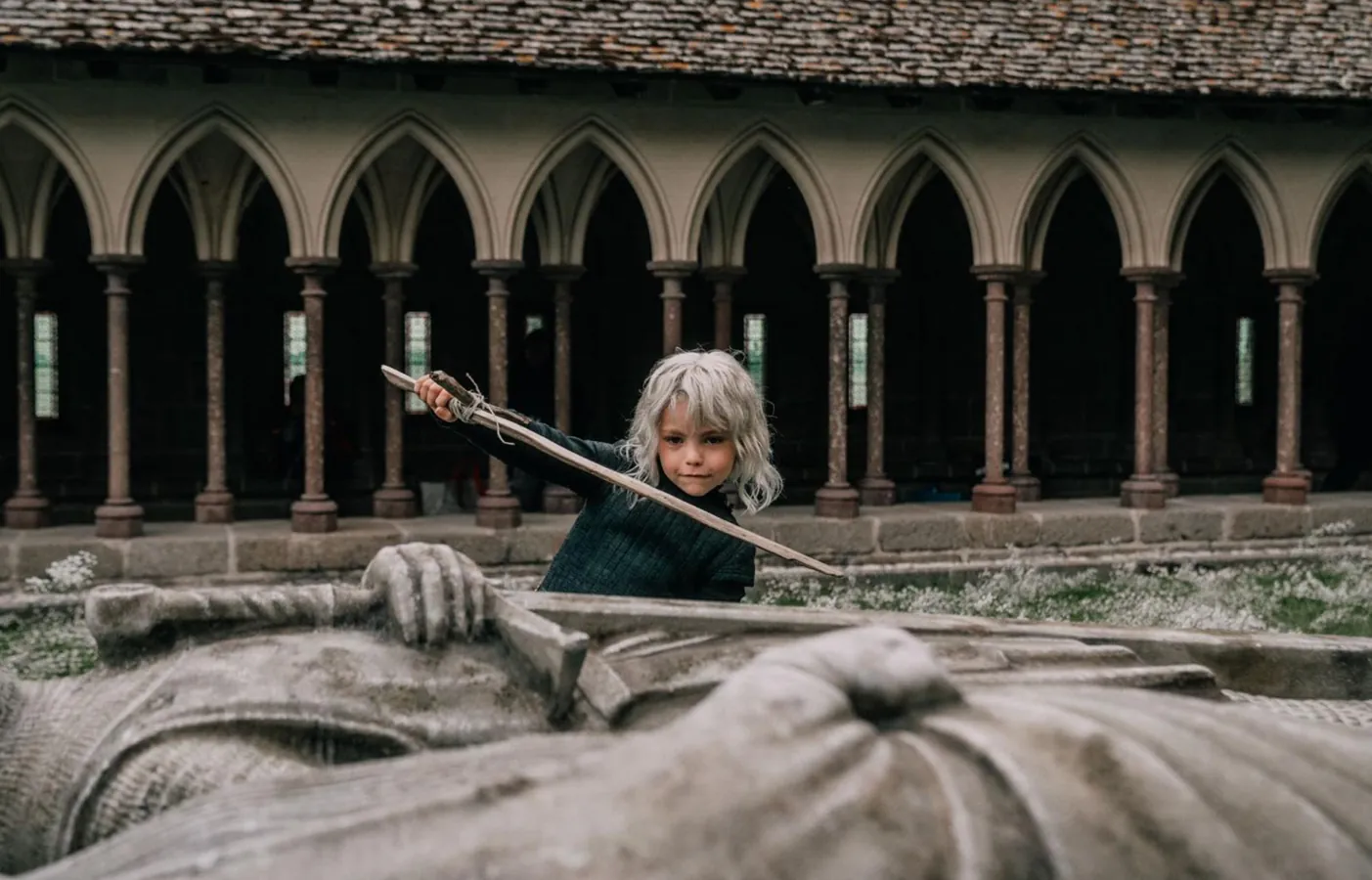 boy plays with sword in front of epic grave